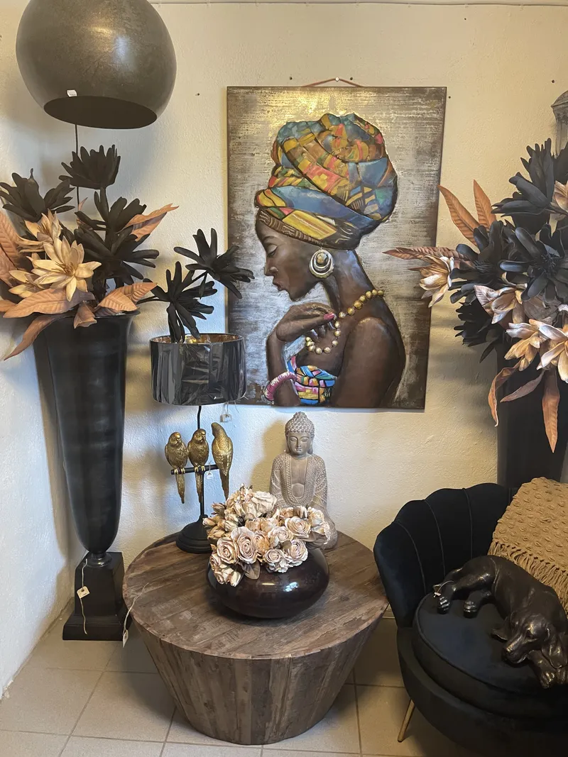 Rundt sofabord i massivt træ med rosenbuket, Buddha-figur og sort skalstol i fløjl